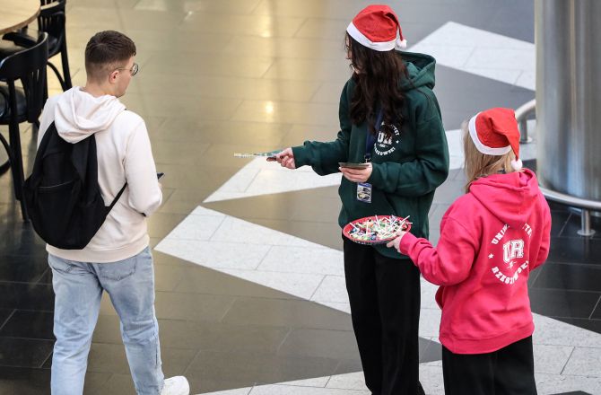 studentki w czapce mikołaja rozdają ulotki